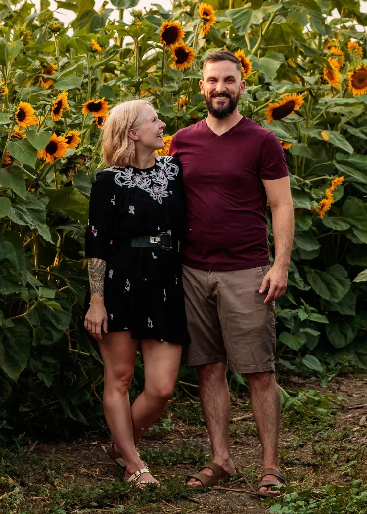 Hannah and Colby standing together in a cornfield